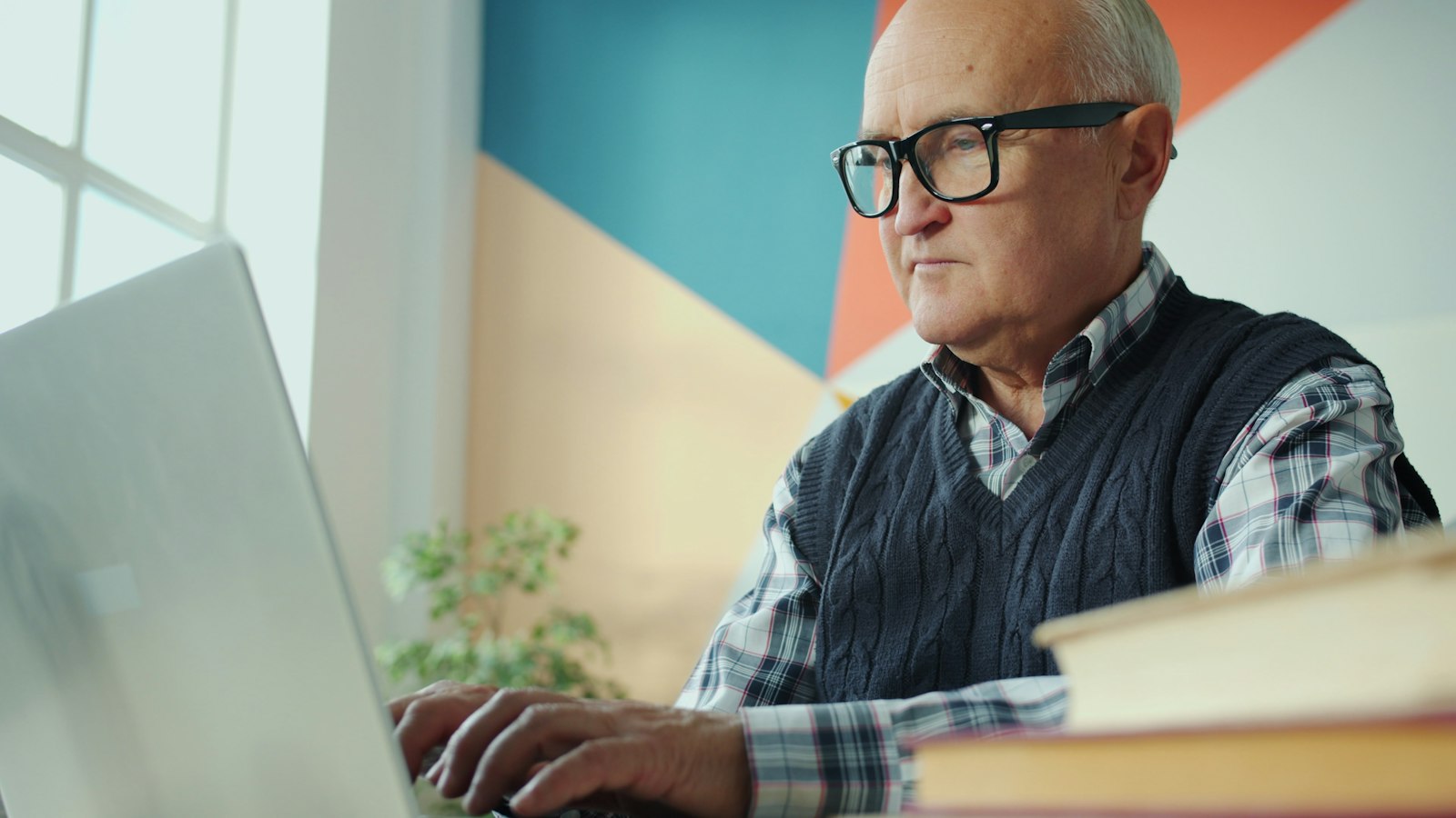 Oudere man met bril werkt op een laptop, een doelgroep die een recruitmentstrategie vaak overslaat