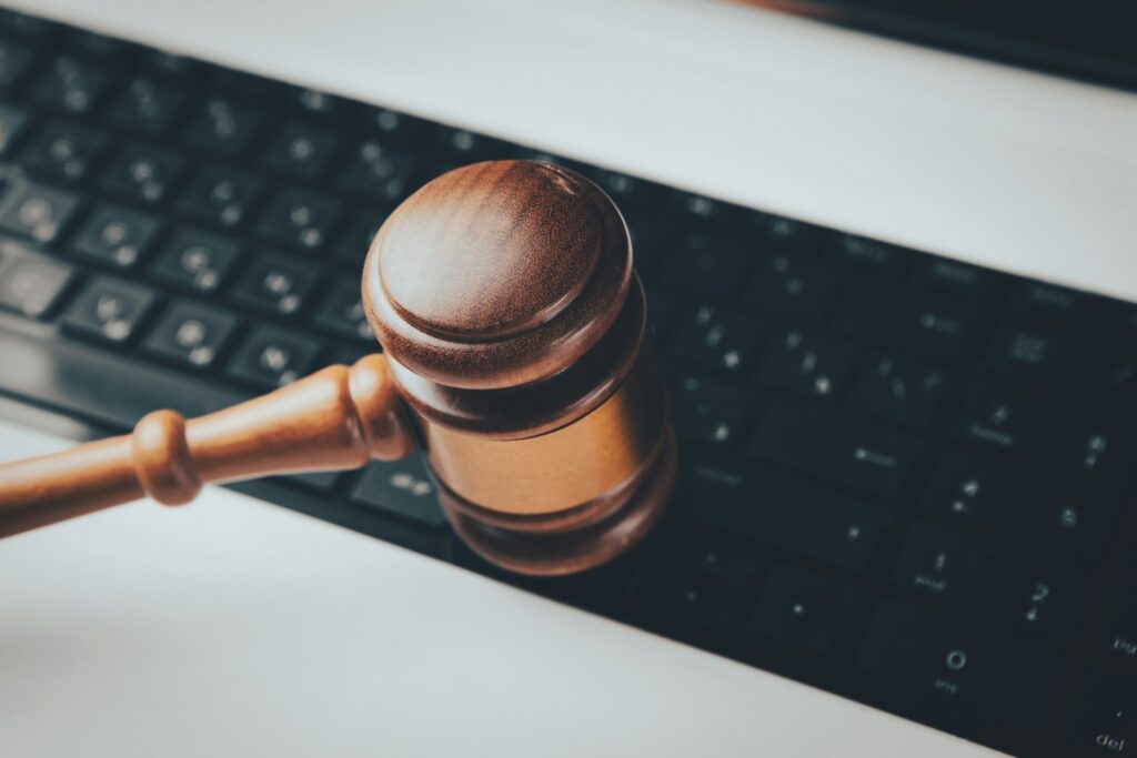 Houten rechtershamer op een laptoptoetsenbord, beeld bij de AI Act voor recruitment