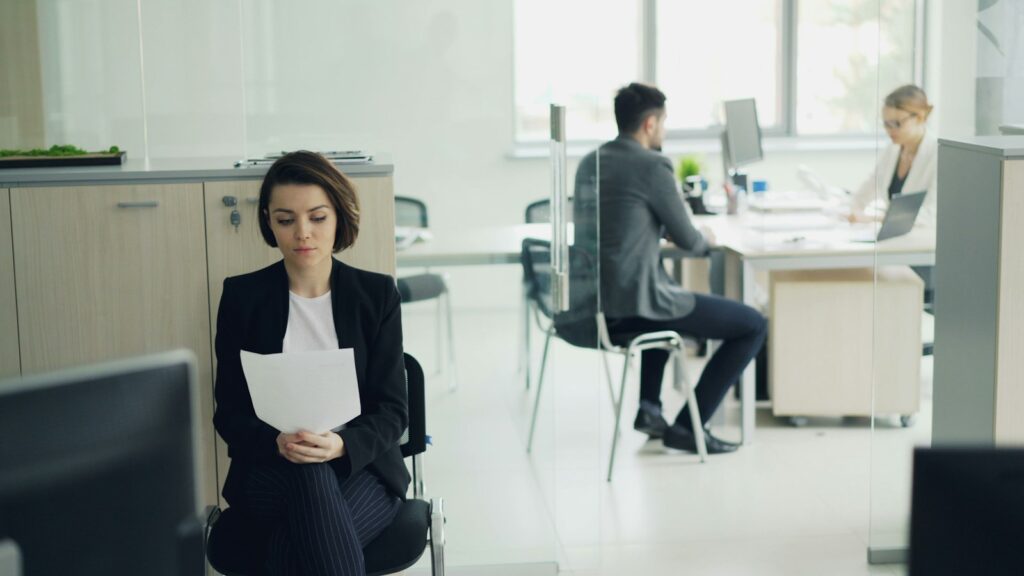 Vrouw zit op kantoor met papieren in haar handen, een latente kandidaat die bij lage arbeidsmobiliteit op haar plek blijft