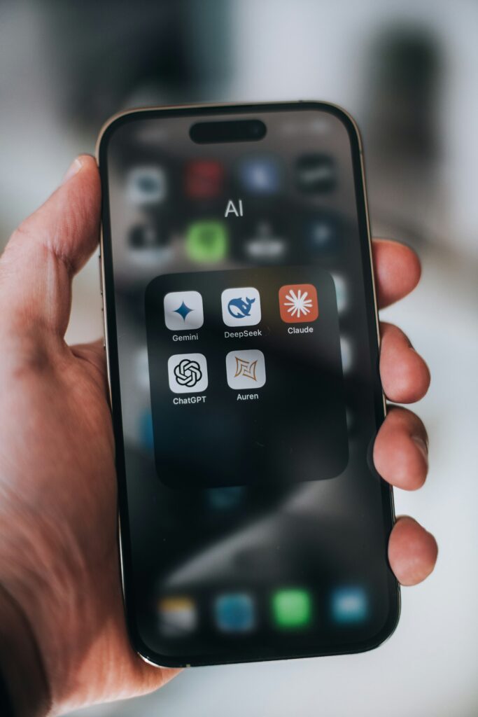 Hand houdt een telefoon vast met verschillende AI-apps op het scherm, de nieuwe plek waar employer branding en AI elkaar raken
