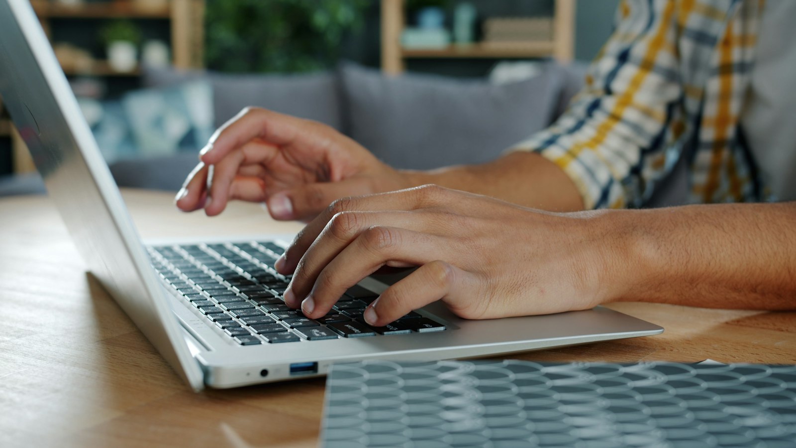 Iemand typt aan een bureau op een laptop: een vacaturetekst schrijven vanuit de kandidaat